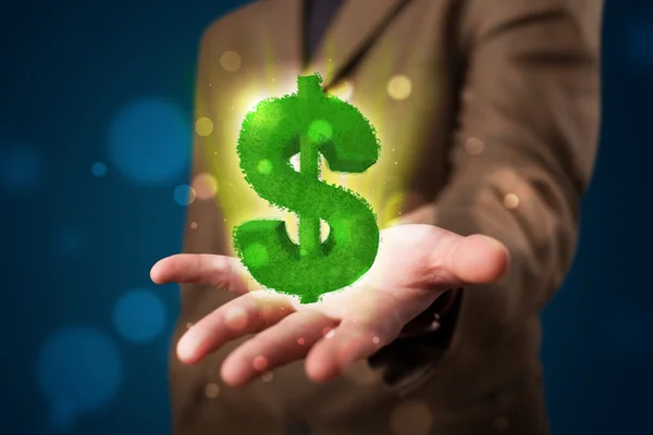 Young businessman presenting green glowing dollar sign — Stock Photo, Image