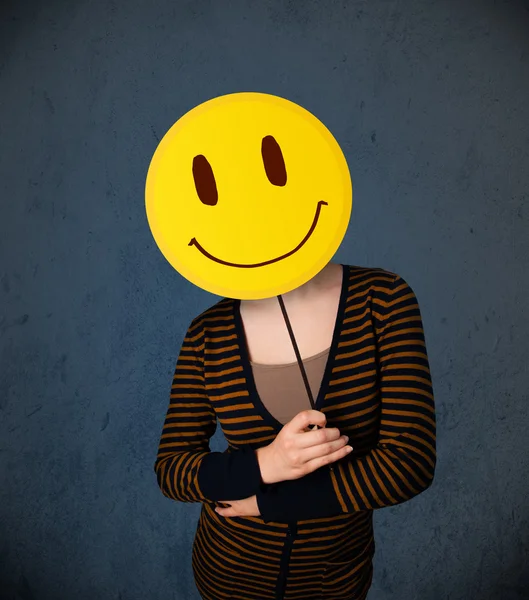 Junge Frau mit einem Smiley-Emoticon — Stockfoto