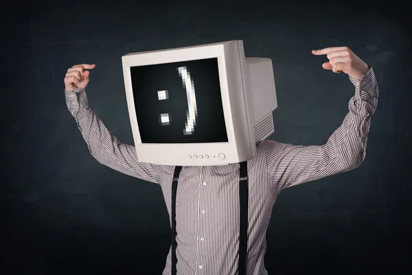 Lustiger junger Geschäftsmann mit Monitor auf dem Kopf und Smiley auf dem Kopf — Stockfoto