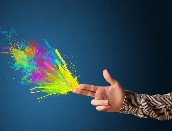 Colorful splashes are coming out of gun shaped hands — Stock Photo, Image