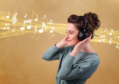 Kulaklıklı genç bir kadın müzik dinliyor.
