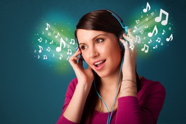 Kulaklıklı genç bir kadın müzik dinliyor.