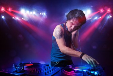 Genç dj kayıtları bir kalabalığın önünde sahnede karıştırma