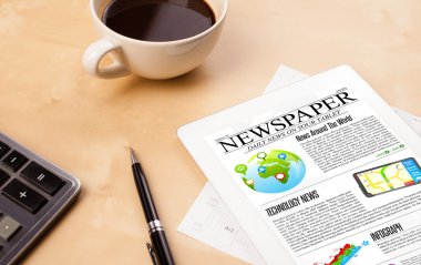 Tablet bilgisayarı haberleri ekranda bir fincan kahveyle sunar.