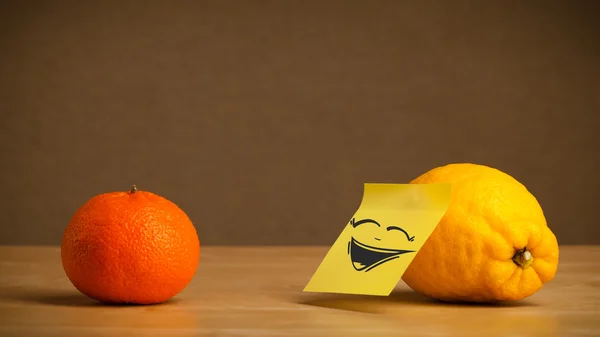 Lemon with post-it note laughing on orange — Stock Photo, Image