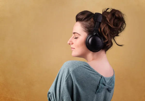 Young woman with headphones listening to music with copy space — Stock Photo, Image