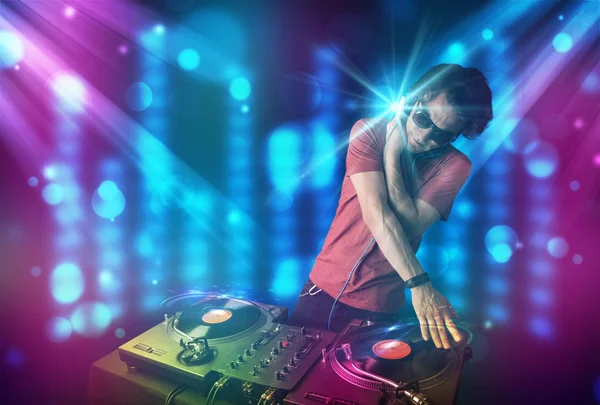 Dj mezclando música en un club con luces azules y moradas — Foto de Stock