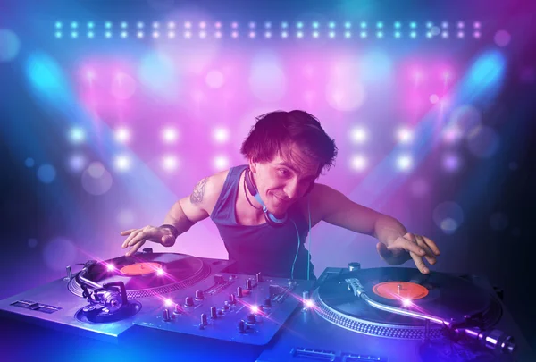 Disc jockey mixant de la musique sur platines sur scène avec des lumières et — Photo