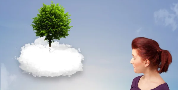 Niña apuntando a un árbol verde en la parte superior de una nube blanca — Foto de Stock