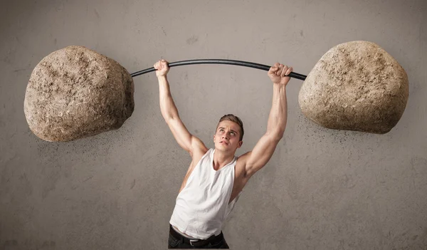 Hombre muscular levantando grandes pesos de piedra de roca — Foto de Stock