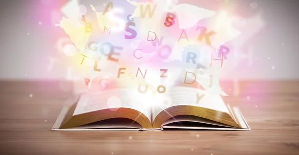 Otevřená kniha se zářivými písmeny na betonovém pozadí — Stock fotografie