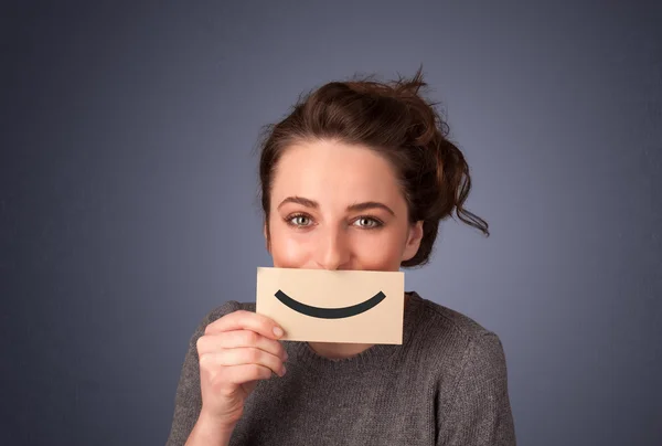 Glückliche hübsche Frau mit Karte und lustigem Smiley — Stockfoto