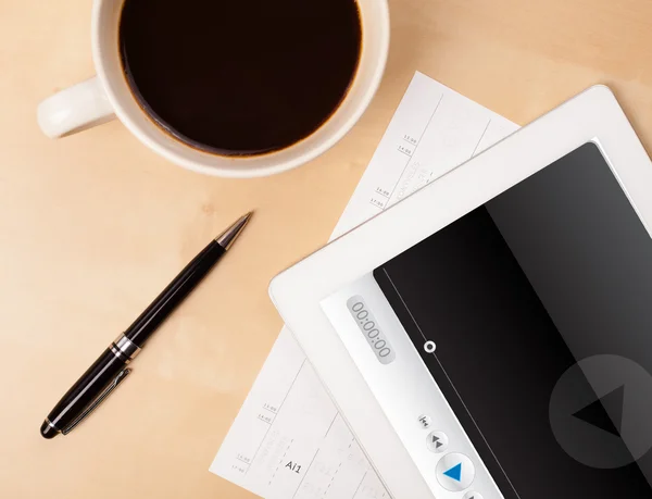 Tablet pc showing media player on screen with a cup of coffee on — Stock Photo, Image