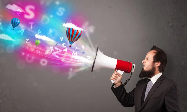 Man shouting into megaphone and abstract text and balloons come — Stock Photo, Image