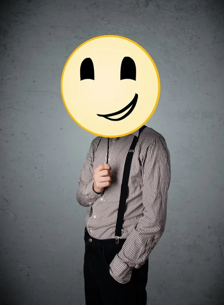 Empresário segurando um emoticon rosto sorridente — Fotografia de Stock