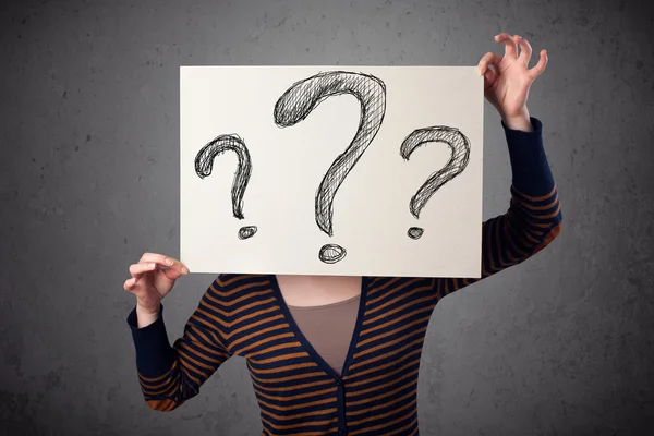 Woman holding paper with drawed question marks in front of her h — Stock Photo, Image