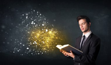 Genç adam sihirli bir kitap okuyor.