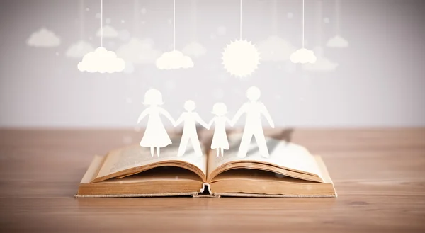 Pappfiguren der Familie auf aufgeschlagenem Buch — Stockfoto