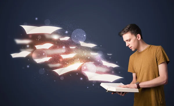 Fiatal srác olvasó egy könyv repülő lapok jönnek ki a dob — Stock Fotó