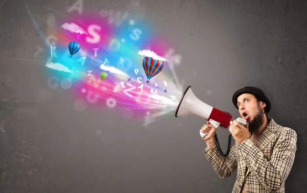 Man shouting into megaphone and abstract text and balloons come — Stock Photo, Image