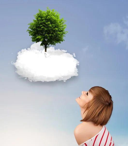 Niña apuntando a un árbol verde en la parte superior de una nube blanca — Foto de Stock