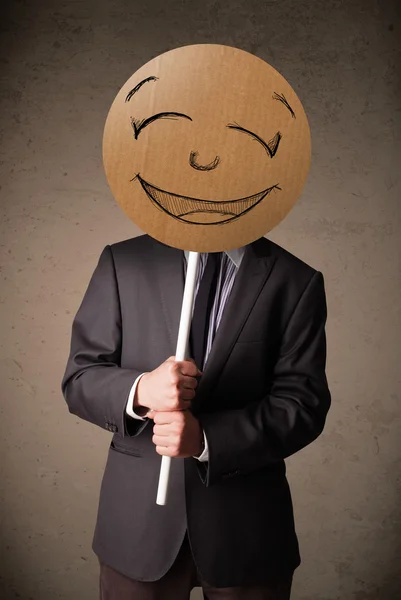 Üzletember, smiley arc deszkán tartja — Stock Fotó