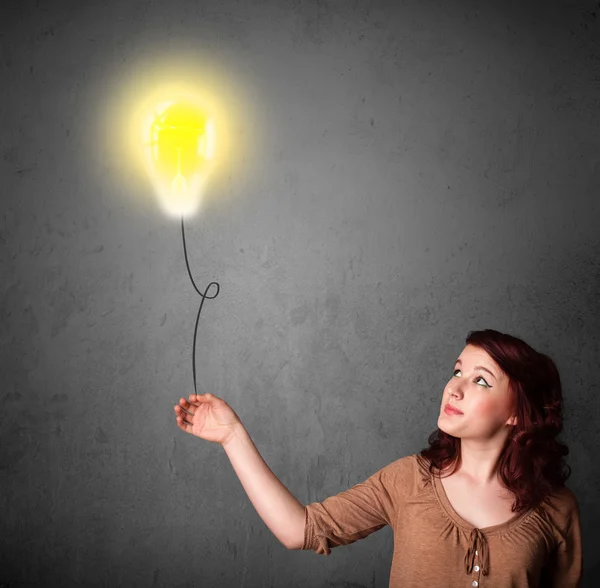 Woman holding a lightbulb balloon — Stock Photo, Image