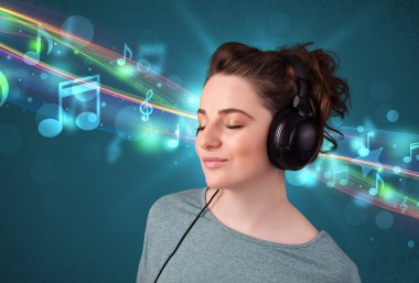 Kulaklıkla müzik dinleyen genç bir kadın.
