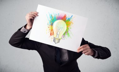 boya sıçraması ve lightbul ile bir karton tutan işadamı