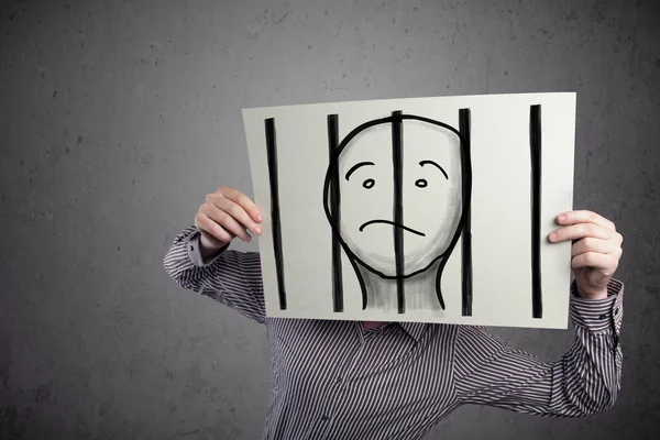 Businessman holding a paper with a prisoner behind the bars on i — Stock Photo, Image