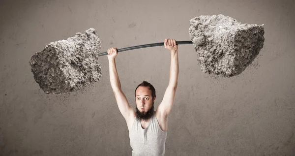 Skinny guy lifting large rock stone weights — Stock Photo, Image