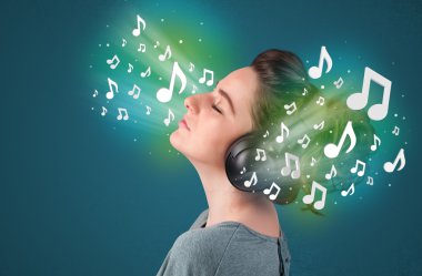 Kulaklıklı genç bir kadın müzik dinliyor.