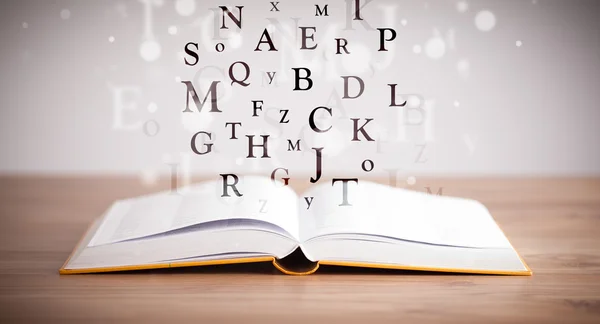 Geopend boek met vliegende letters — Stockfoto