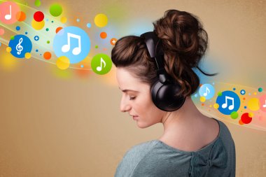 Kulaklıkla müzik dinleyen genç bir kadın.
