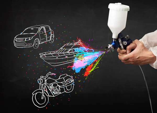 Man met airbrush spray paint met auto, boot en motorfiets tekenen — Stockfoto