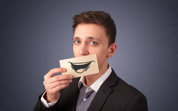 Ευτυχής επιχειρηματίας κρατώντας αστεία λευκή κάρτα στο στόμα του — Φωτογραφία Αρχείου