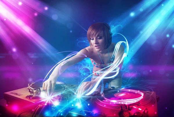 Енергетична Джи дівчина, що змішує музику з потужними світловими ефектами — стокове фото