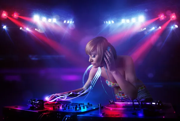 Disco jockey menina tocando música com efeitos de feixe de luz no palco — Fotografia de Stock