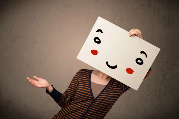 Woman holding a cardboard with a smiley face on it — Stock Photo, Image