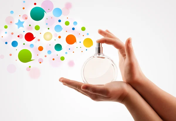 Woman hands spraying colorful bubbles from beautiful perfume bottle — Stock Photo, Image