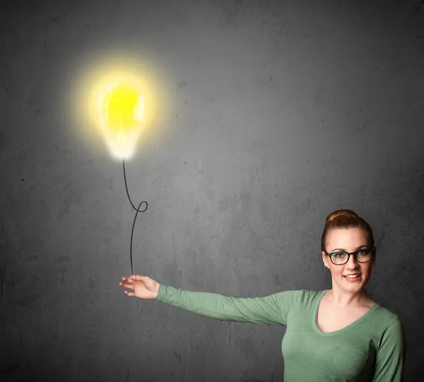 Woman holding a lightbulb balloon — Stock Photo, Image