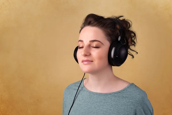 Young woman with headphones listening to music with copy space — Stock Photo, Image