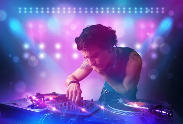 Disc jockey mixando musica sui giradischi sul palco con luci e — Foto Stock