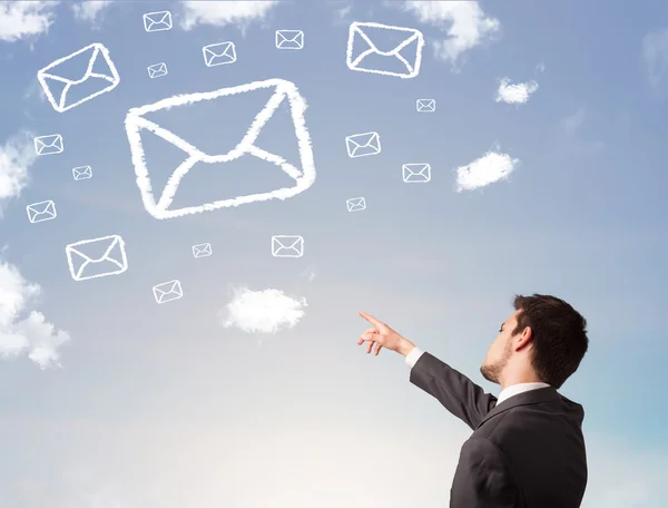 Hombre de negocios mirando el símbolo de correo nubes en el cielo azul —  Fotos de Stock