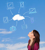 Příležitostná dívka při pohledu na cloud výpočetní koncept na modré obloze