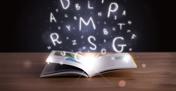 Open book with glowing letters flying out — Stock Photo, Image