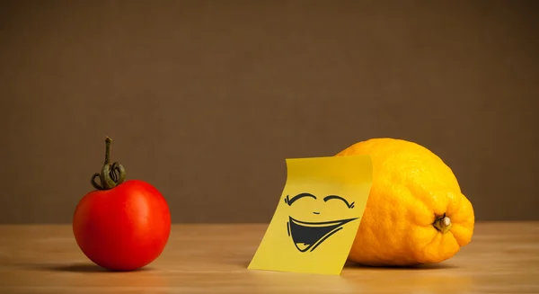 Lemon with post-it note laughing on tomato — Stock Photo, Image