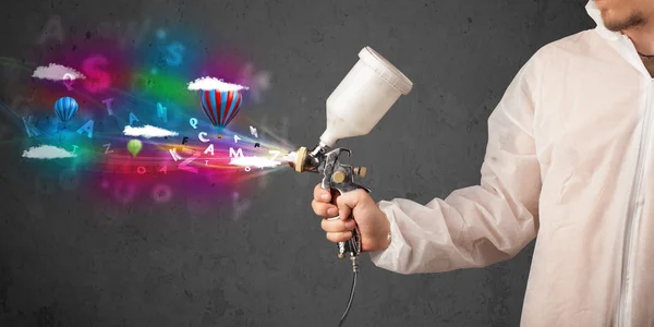 Worker with airbrush and colorful abstract clouds and balloons — Stock Image Worker with airbrush and colorful abstract clouds and balloons Royalty Free Stock Images