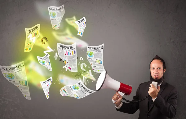 Guy yelling into loudspeaker and newspapers fly out — Stock Photo, Image