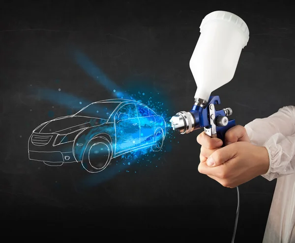 Worker with airbrush gun painting hand drawn car lines — Stock Photo, Image